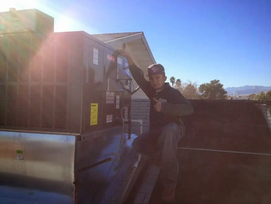 HVAC technician performing HVAC Inspection on a rooftop unit in Alamogordo